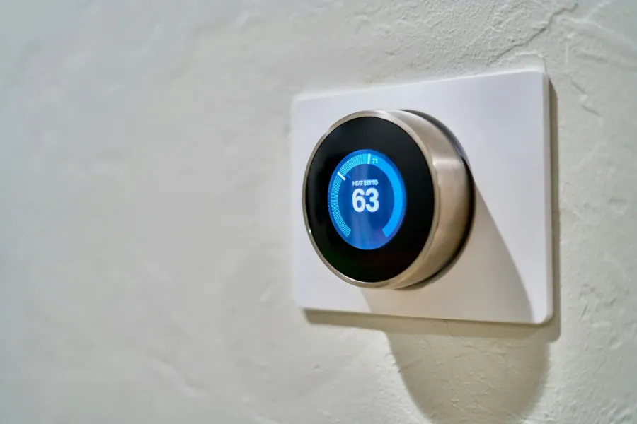 A homeowner checking a wall-mounted thermostat during an AC troubleshooting call